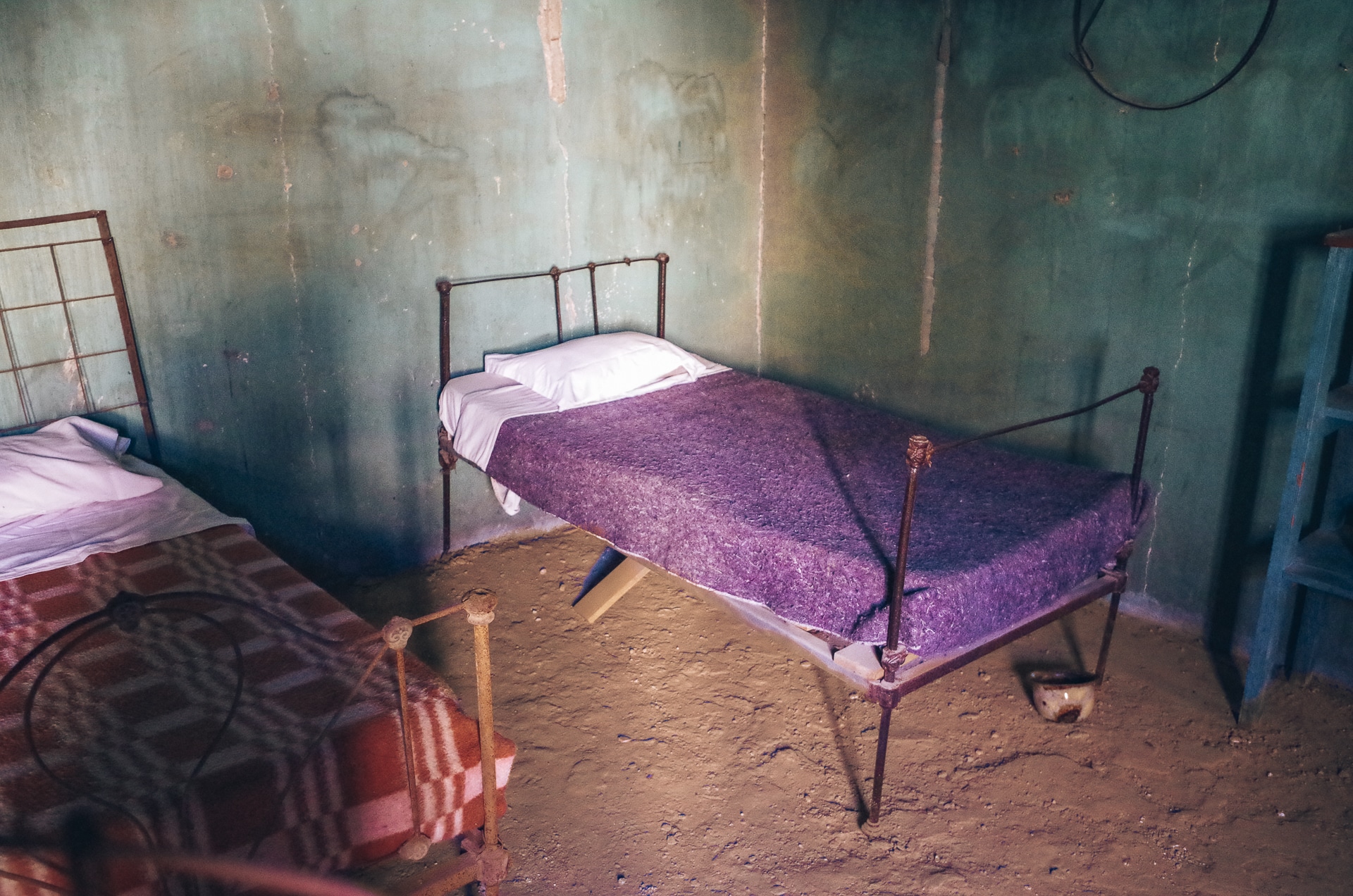deux vieux lits dans une chambre au sol de terre battue à Humberstone