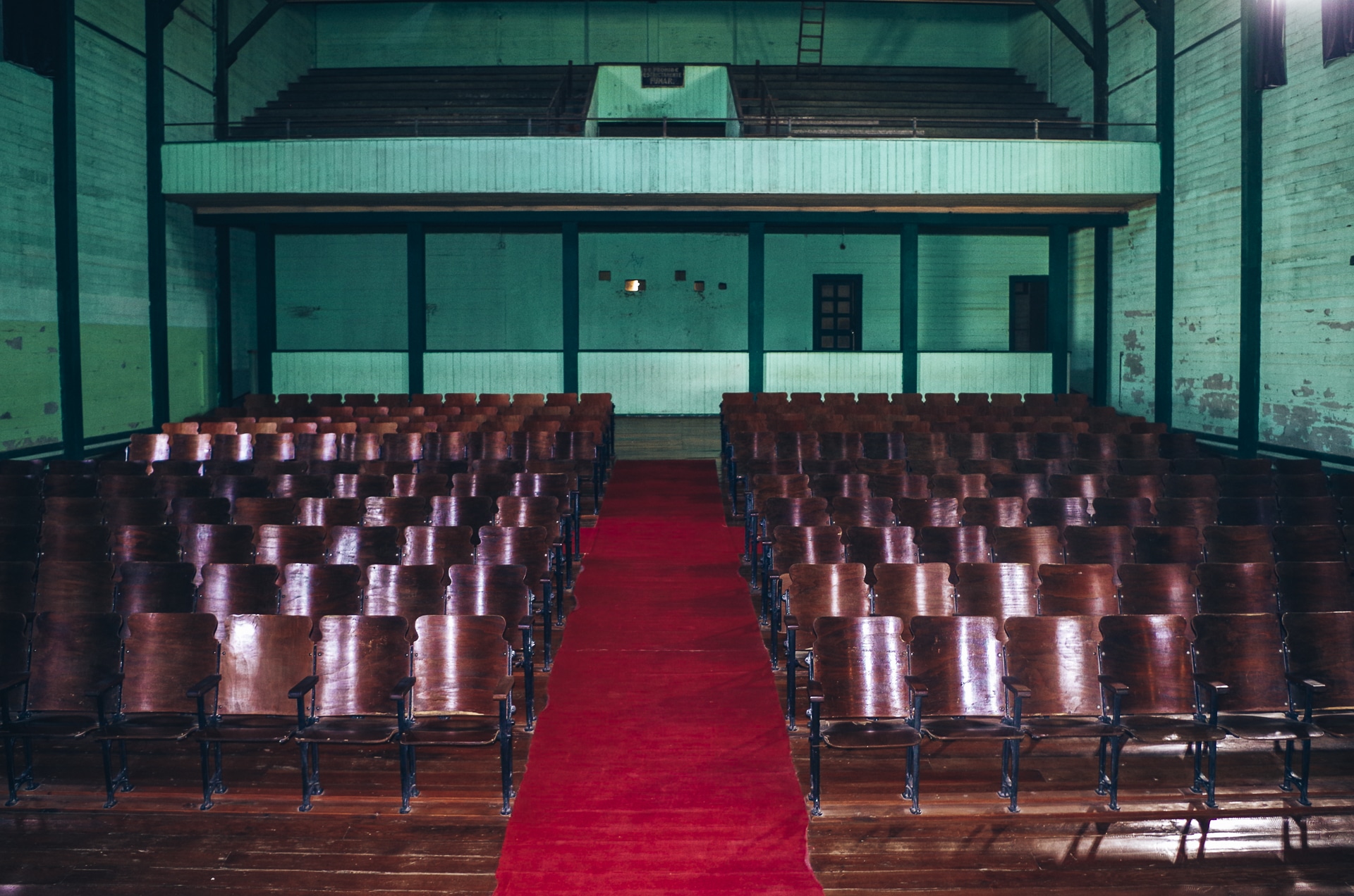intérieur du théâtre d'Humberstone avec ses sièges en bois et son tapis rouge