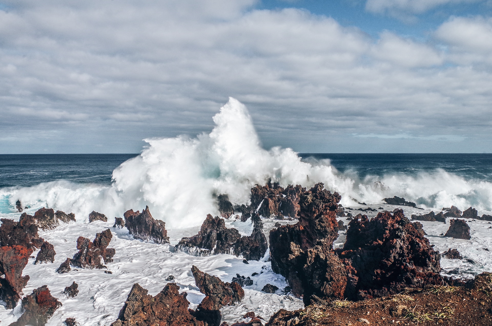 vague déferlant sur des roches volcaniques l'île de Pâques