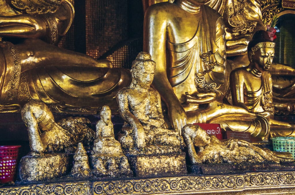 plusieurs statuettes de bouddha dans différentes positions recouvertes d'or