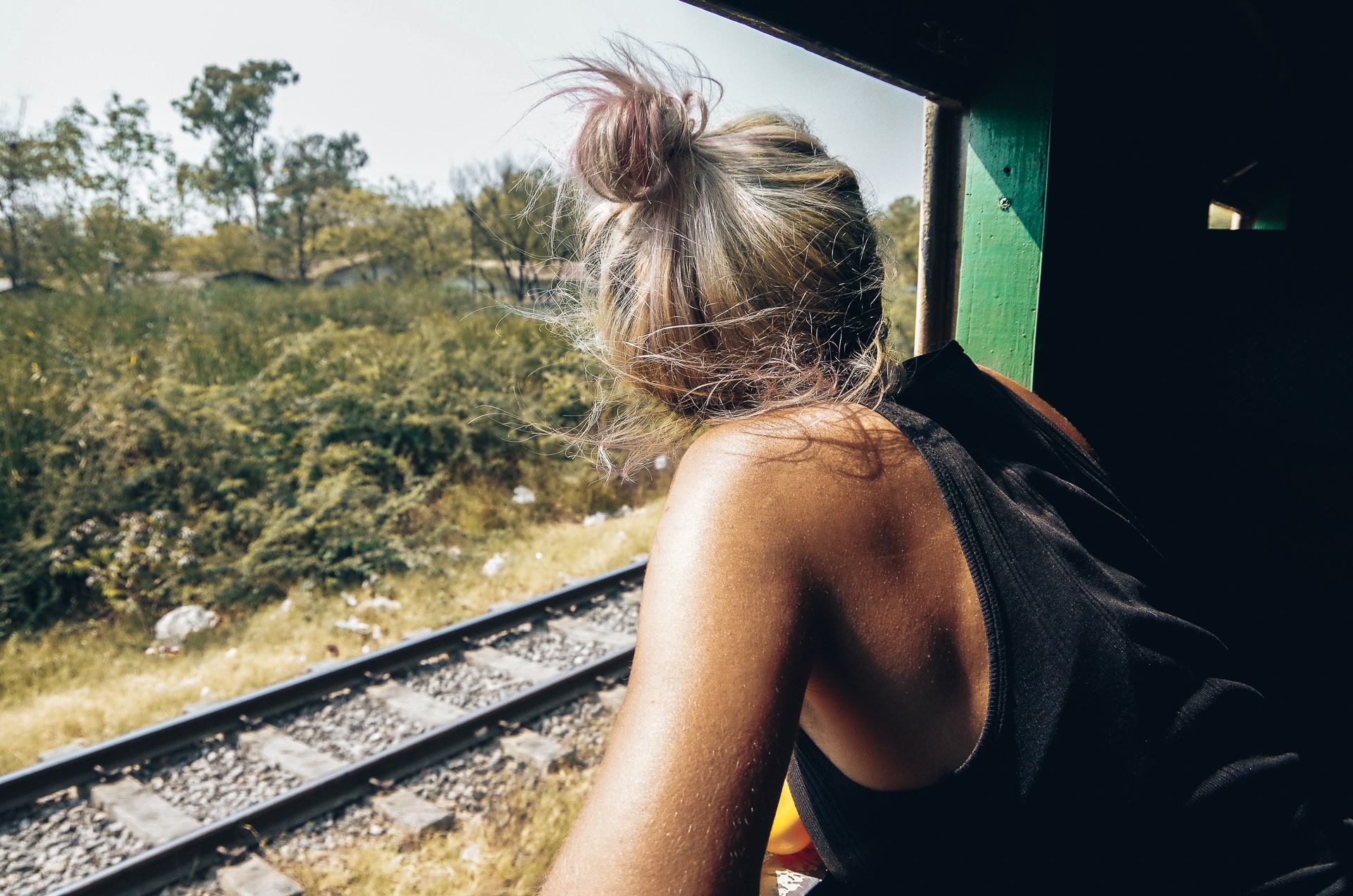 femme à la fenêtre d'un train admirant le paysage au Myanmar