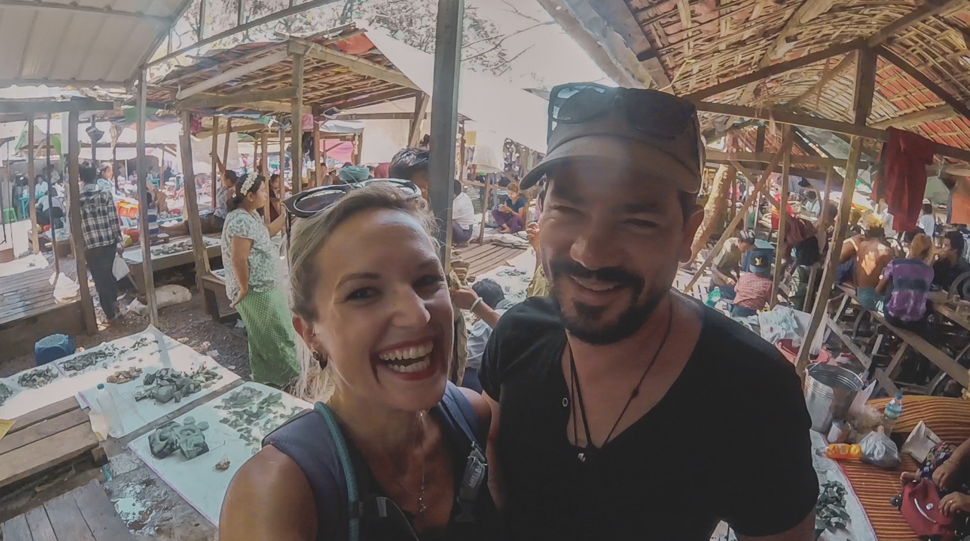 couple souriant au milieu du marché de pierre fine  à Mandalay