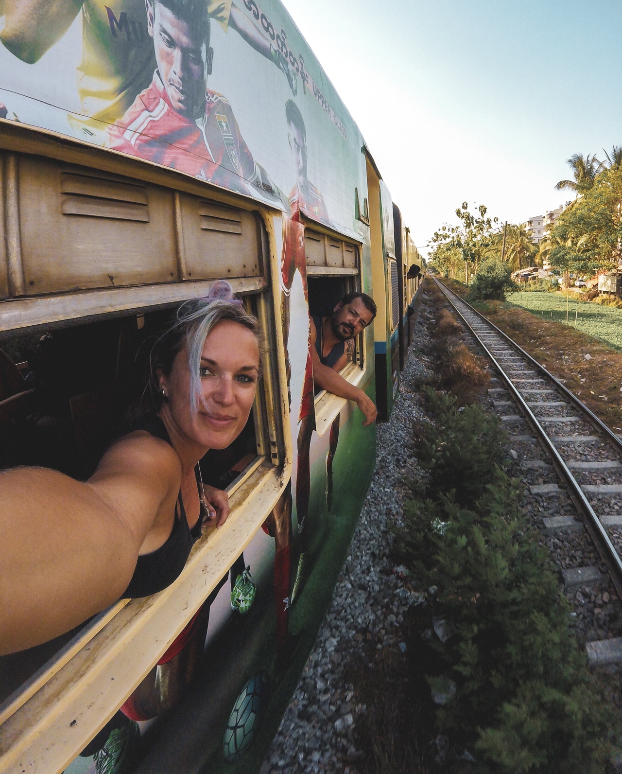 couple prenant un selfie à travers les fenêtres d'un train voyager en train au Myanmar
