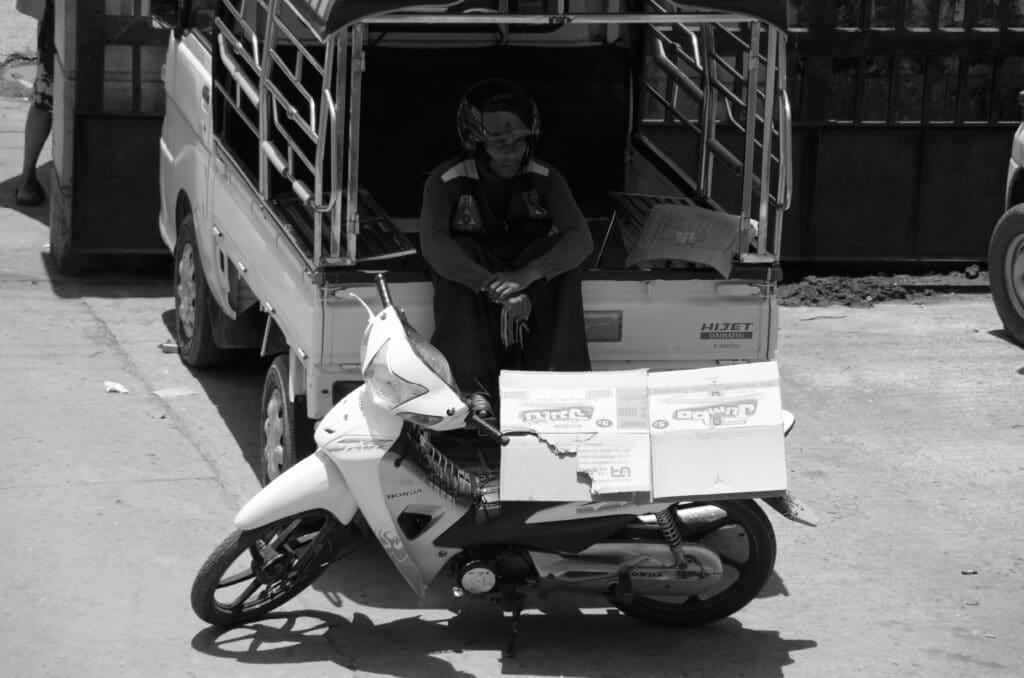 homme attendant à l'arrière d'un pick up au Myanmar moyen de transport Myanmar