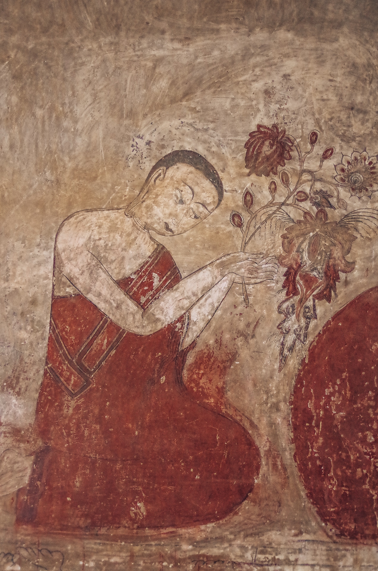 peinture de bouddha agenouillé tenant des fleurs dans ses mains à Bagan