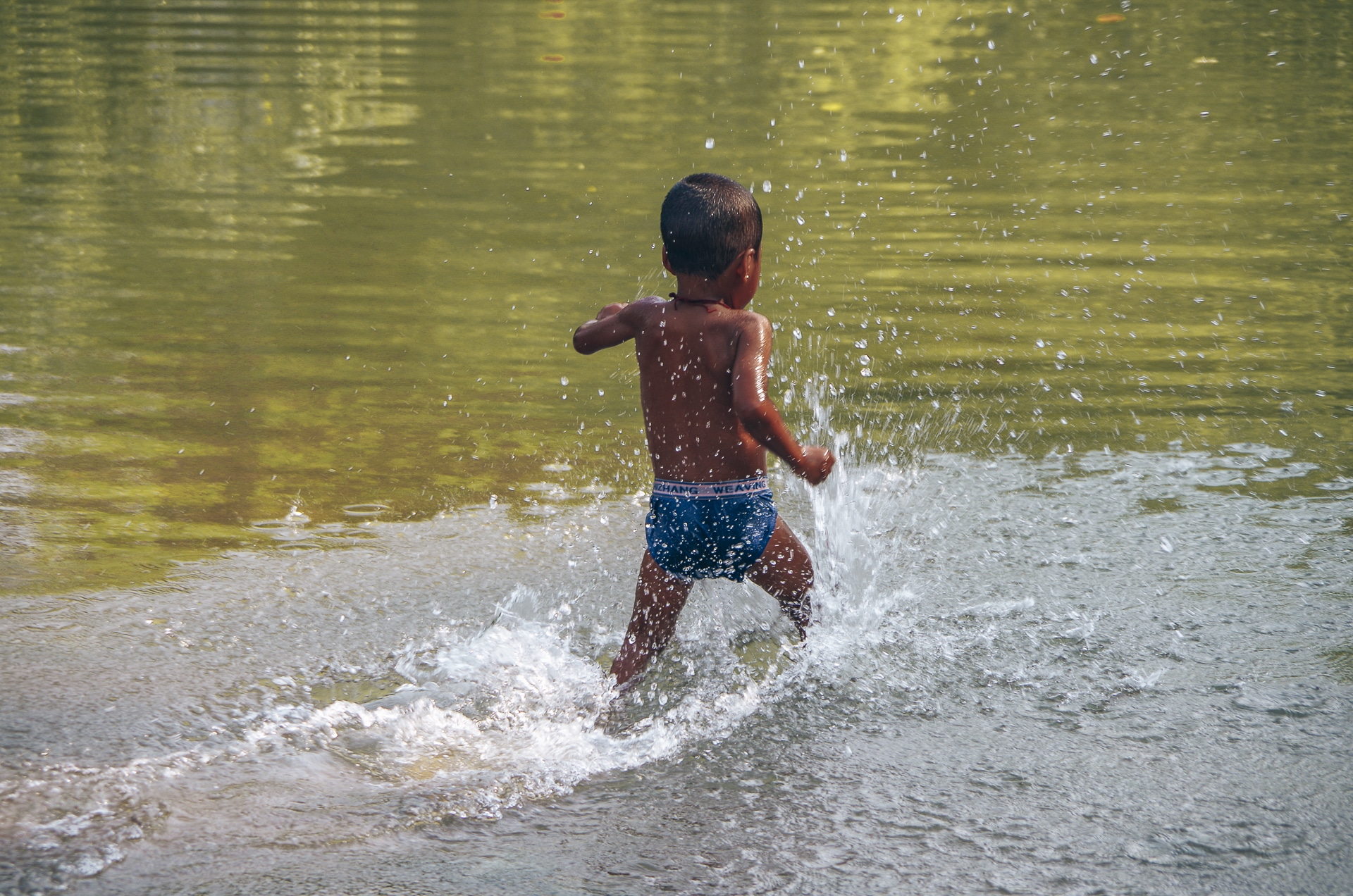 jeune enfant courant dans l'eau d'une rivière Trek Kalaw Inle