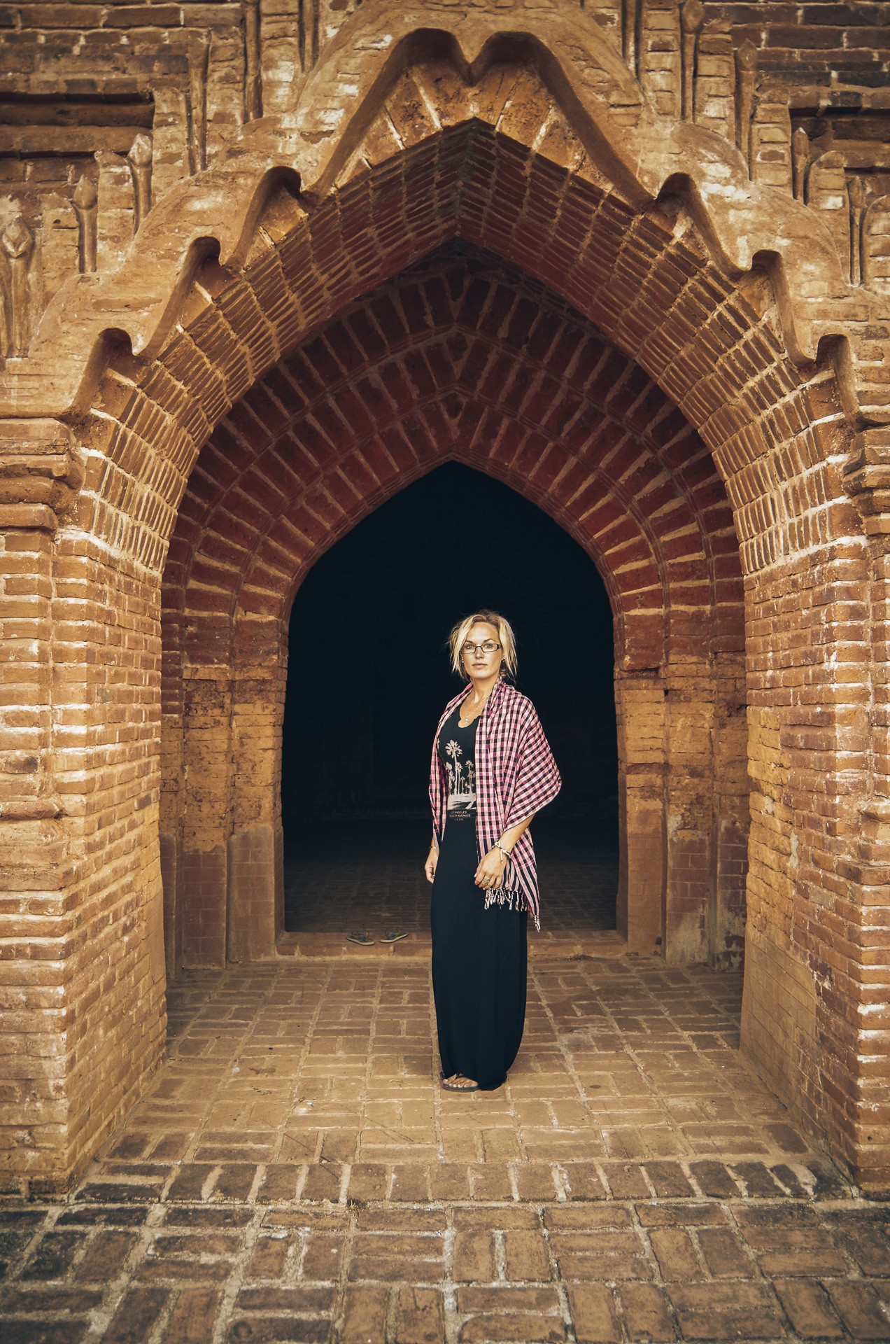 femme posant devant l'entrée d'un temple à Bagan au Myanmar