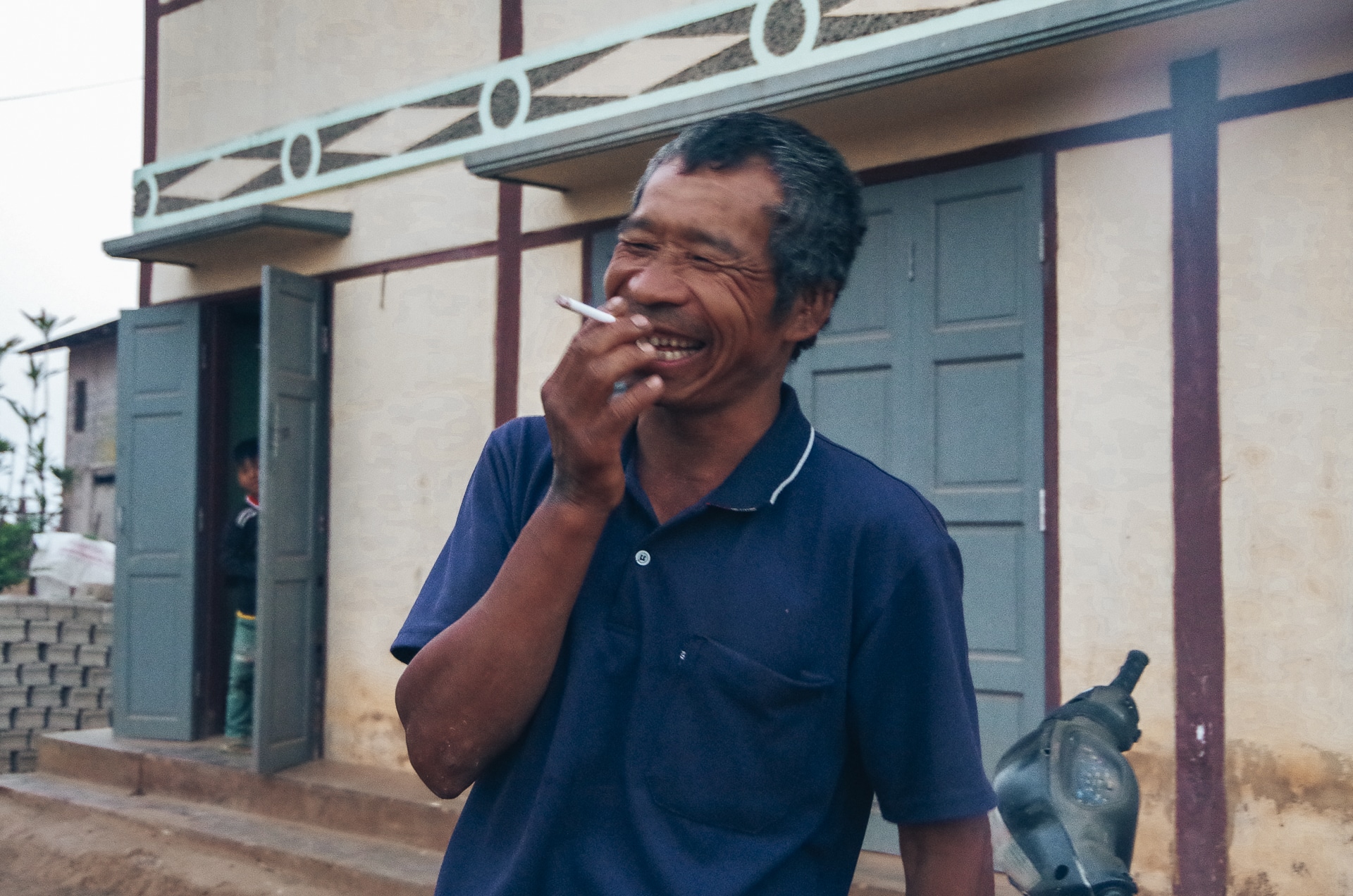homme birman riant aux éclats et tenant une cigarette à la main